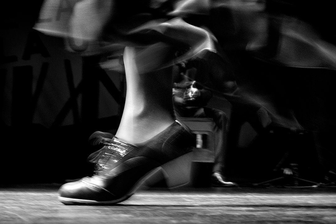Zapatos de baile en movimiento a ras del escenario.